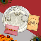 A spiritual Rakhi gift set featuring pooja thali, Rakhi thread, ritual powders, and greeting for heartfelt blessings.
