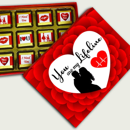 Box of chocolates with a romantic card on a light gray background