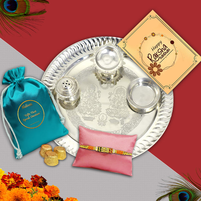 A vibrant Rakhi gift set with silver thali, roli-chawal containers, Rakhi thread, and colorful greeting card.