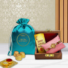 Deluxe Rakhi hamper with wooden box Rakhi, chocolate pouch, greeting card, and ceremonial powders.