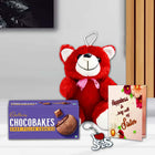 Red teddy bear with a pink bow, Cadbury Chocobakes cookies, keychain, and card 