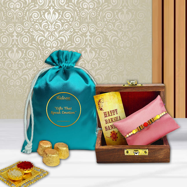Rakhi gift highlighting chocolate delight and tradition with wooden Rakhi box, greeting card, and roli-chawal duo.