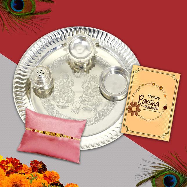 Artistic Rakhi collection featuring 9-inch silver thali, roli-chawal bowls, and a decorative festive card.