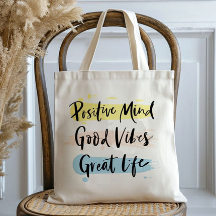 Tote bag with 'Positive Mind Good Vibes Great Life' text on a chair
tote bag for laptop and office use
tote bag with stylish design
tote bag for college students
tote handbag with zipper
