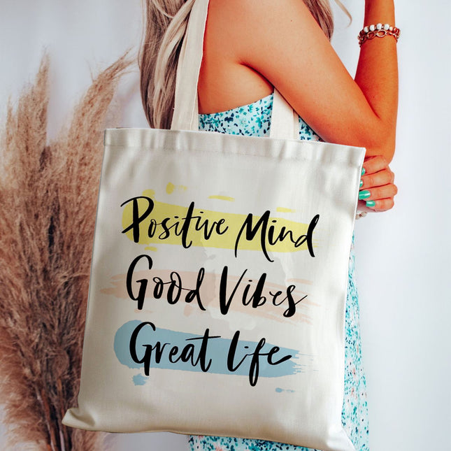 Tote bag with 'Positive Mind Good Vibes Great Life' text held by a person.
classic canvas tote handbag
trendy office tote for ladies