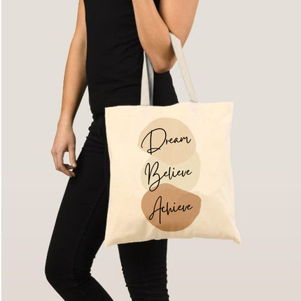 Tote bag with 'Dream Believe Achieve' text held by a person on a plain background
stylish office bag for women