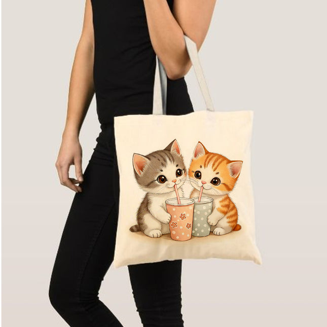 Tote bag with cartoon cats drinking from colorful cups held 
by a person.
best tote bag for travel
elegant tote bag for ladies